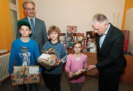 OB Kuhn übergibt im Familienzentrum St. Josef die Geschenke vom Kinderwunschbaum an Anna-Sophia, Leon und Oliver (v.r.n.l.). Im Hintergrund: Michael Leibinger, Geschäftsführer der St. Josef gGmbH. Foto: Kraufmann/Hörner, Rechte: Stadt